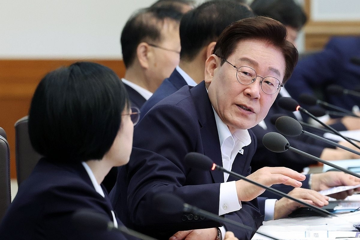 李在明在会议上与韩圣淑进行交流。