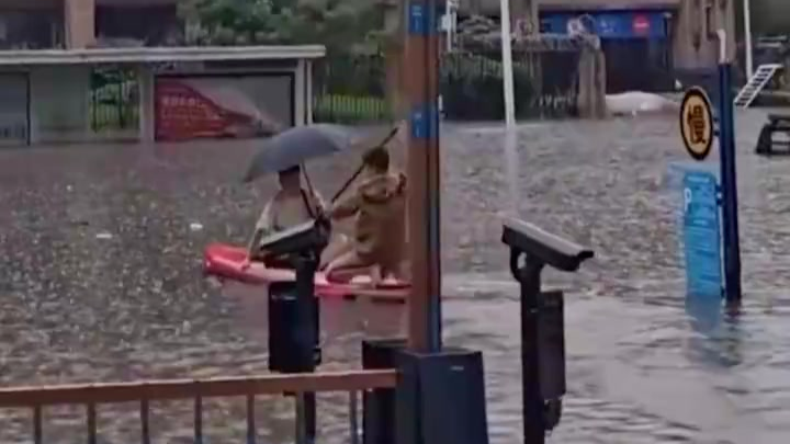 沈阳男子冒雨划船护送被困路人