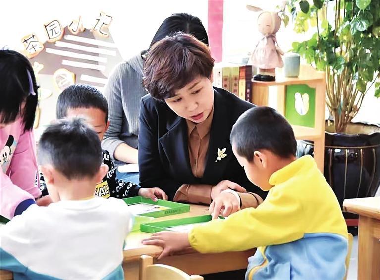 芦秀红与幼儿交流　 兰州新区报记者　姜波　摄