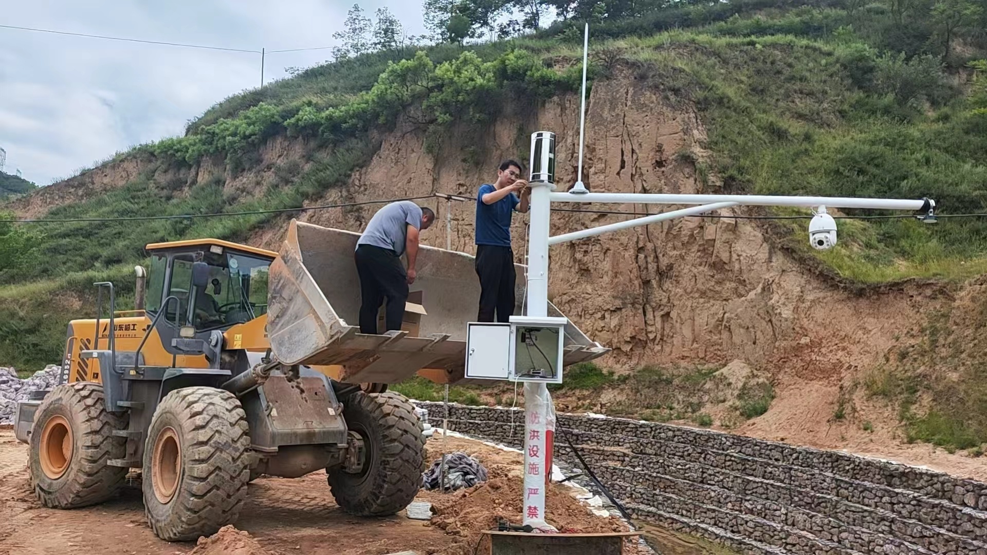 图为工作人员正在维护检修水位站和雨量站设备.jpg
