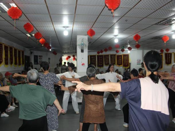 图为队员手把手教老年长辈练习中医养生八段锦。肖丹 供图