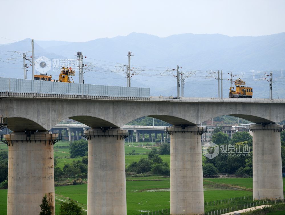 2026年7月22日，在昌九高铁昌北机场站外，南铁南昌供电段的技术人员和中铁武汉电气化局的施工人员正在架设接触网导线。