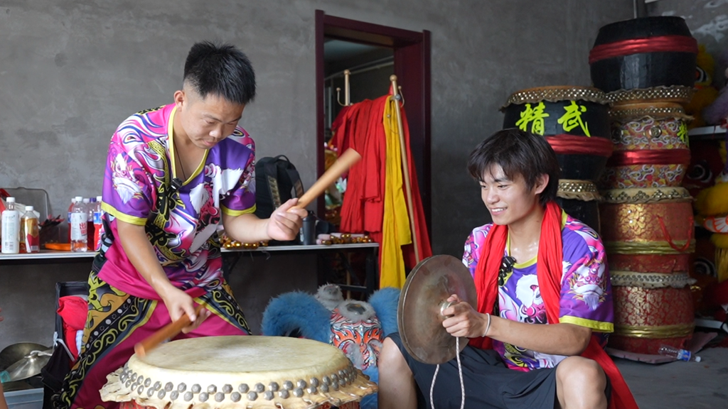 图为袁静飞（左）在教王迎奥打镲。赵新宇 摄
