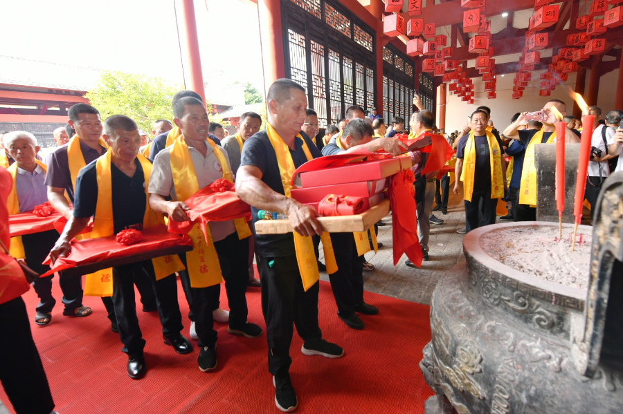 100组宗亲家族长辈向先祖、向承载历史的族谱行鞠躬礼。