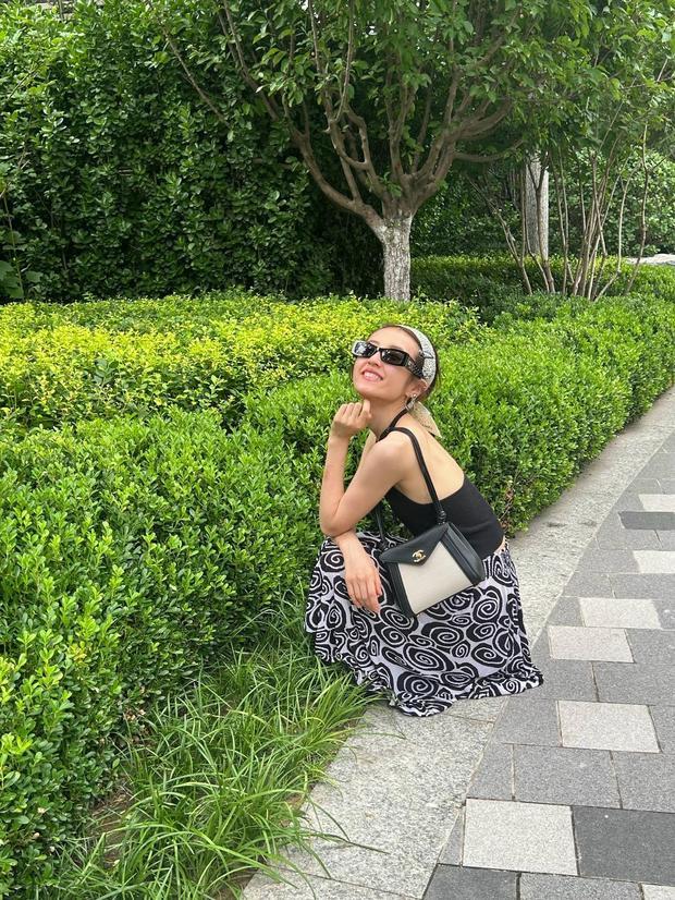 张子枫蹲在地上拍照，笑容满面，松弛感拉满。