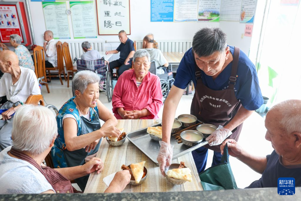 7月23日,在河北省石家庄市元氏县明佑养老院,工作人员为老人提供就餐服务。