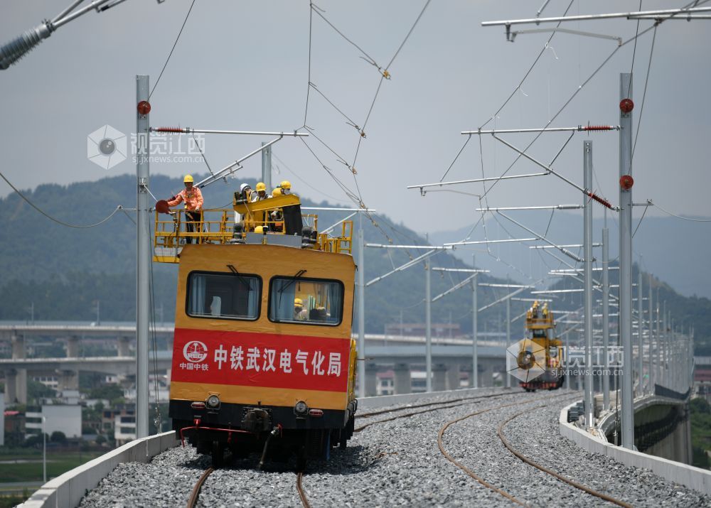 2026年7月22日，在昌九高铁昌北机场站外，南铁南昌供电段的技术人员和中铁武汉电气化局的施工人员正在架设接触网导线。