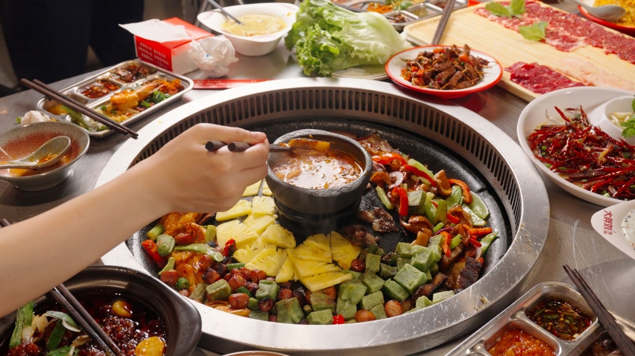 图|洋芋、豆腐和蔬菜围着蘸水铺开,一锅烙锅也把一桌人围到了一起。