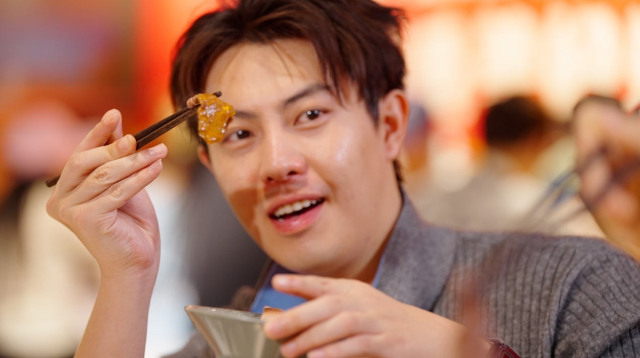 图|唐泊虎夹起刚烙好的食材,趁热尝一口。