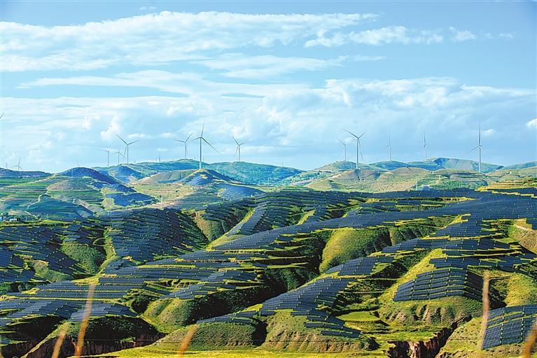 夏日，通渭县马营镇西山村光伏基地，成片的光伏板与远处的风力发电机、梯田绿植交相辉映。新甘肃&middot;甘肃日报通讯员　张子斌