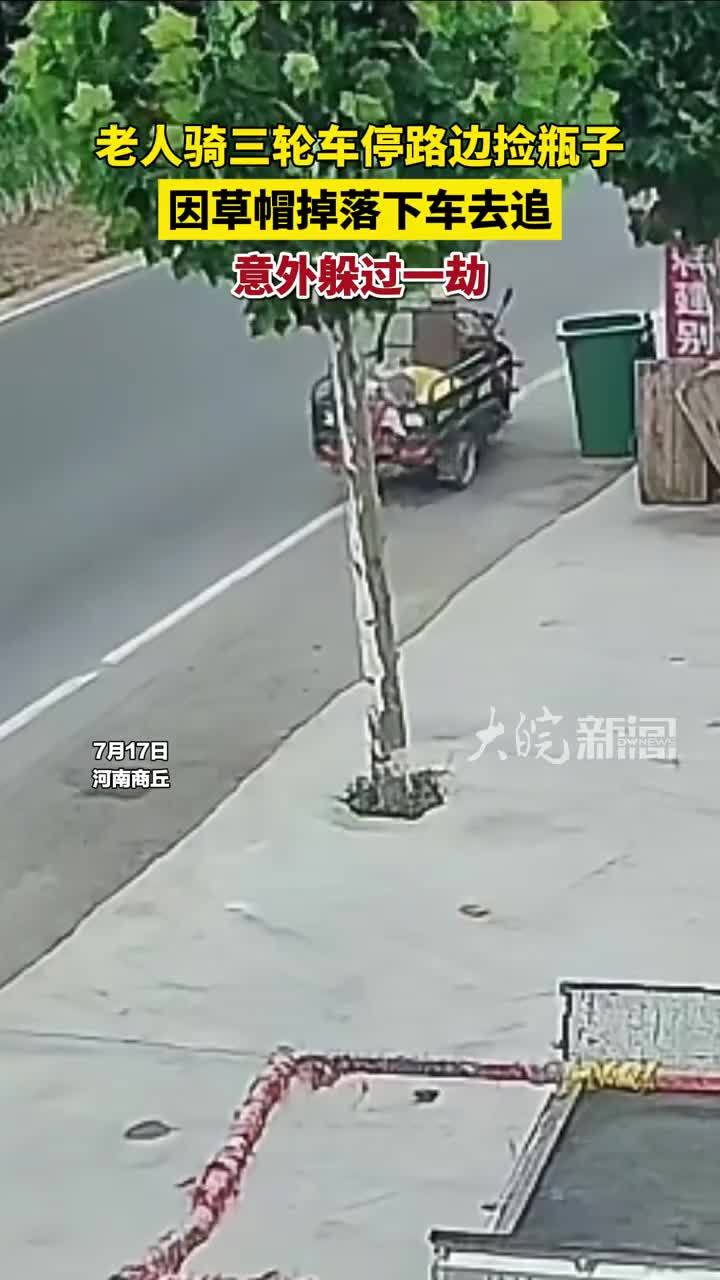 老人骑三轮车停路边捡瓶子，因草帽掉落下车去追，意外躲过一劫