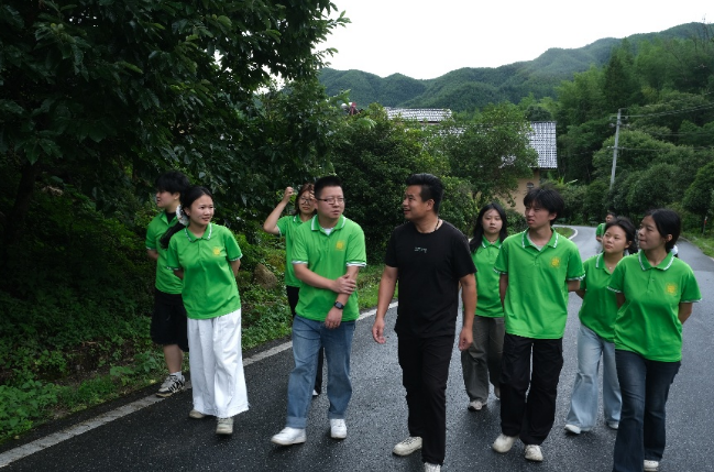 实践团成员与村干部走访村庄,并就墙绘设计和村庄建设需求深入交流