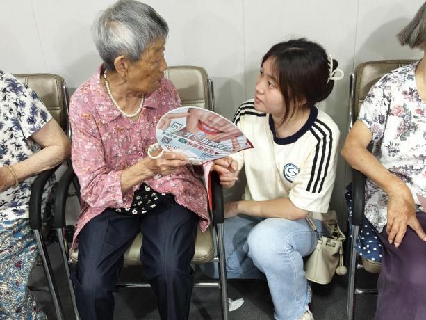 图为队员挥毫书写福字,陪伴老人聊家常。陈思琪 供图