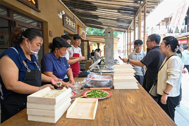 7月24日，游客在西柏坡1948商业街区选购美食。