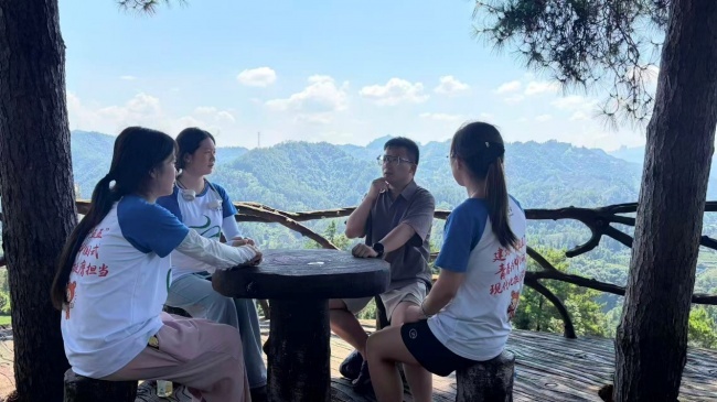 图为实践队员与村基层干部在三棵树观景台座谈,探讨茶产业联农带农发展路径。周萱 供图