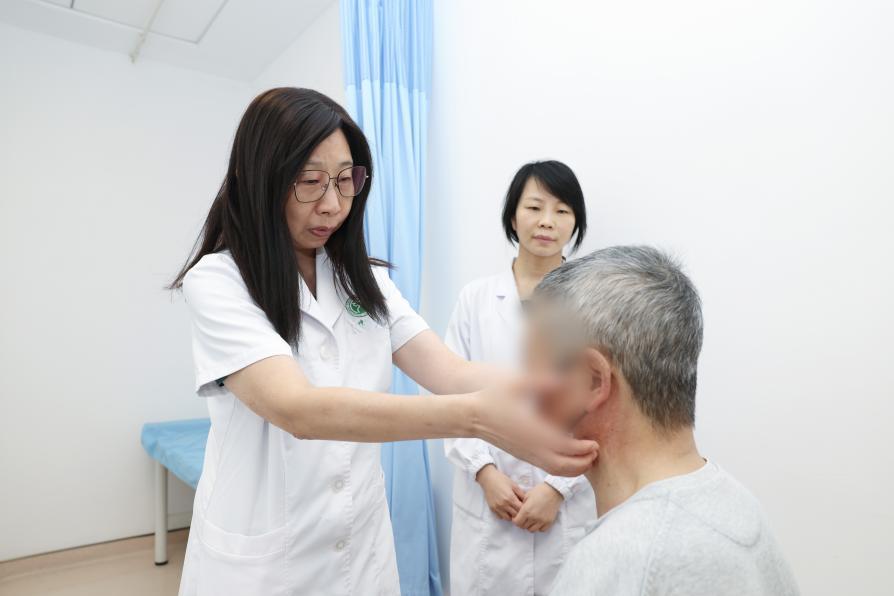 中大医院血液内科主任葛峥正在为患者查体