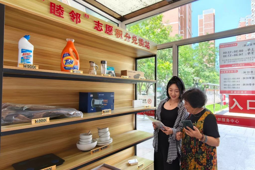 老人在“睦邻”志愿积分兑换站兑换商品。(孟瑶 摄)