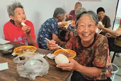 站集镇焦阁村“以孝治家大食堂”里，老人们在愉快就餐。（图/刘建党）