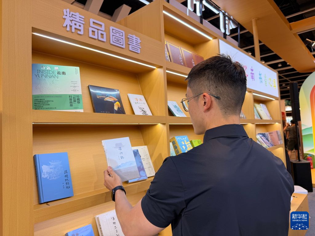 7月19日，读者在香港书展云南展区了解滇版精品图书。新华社记者 黄茜恬 摄