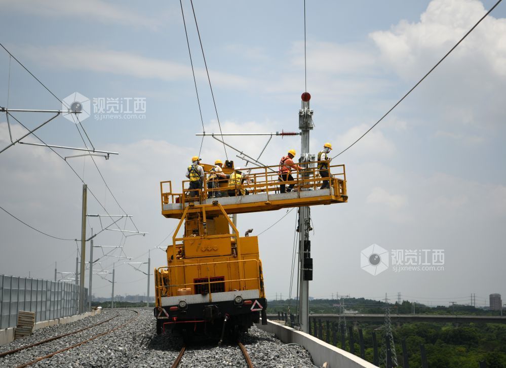 2026年7月22日，在昌九高铁昌北机场站外，南铁南昌供电段的技术人员和中铁武汉电气化局的施工人员正在架设接触网导线。