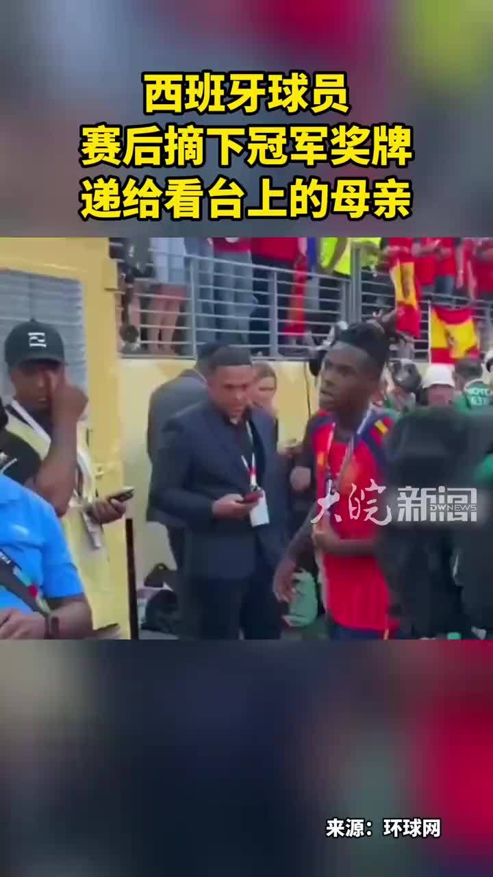 西班牙球员 赛后摘下冠军奖牌 递给看台上的母亲