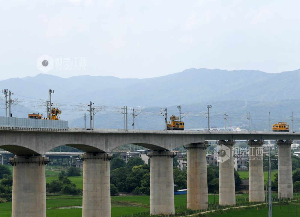 2026年7月22日，在昌九高铁昌北机场站外，南铁南昌供电段的技术人员和中铁武汉电气化局的施工人员正在架设接触网导线。