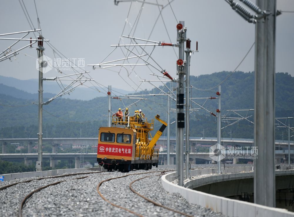 2026年7月22日，在昌九高铁昌北机场站外，南铁南昌供电段的技术人员和中铁武汉电气化局的施工人员正在架设接触网导线。