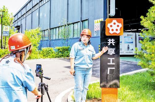 6月23日,张家口市北方中星集团共享工厂员工在车间前直播。 本报记者 赵 杰摄