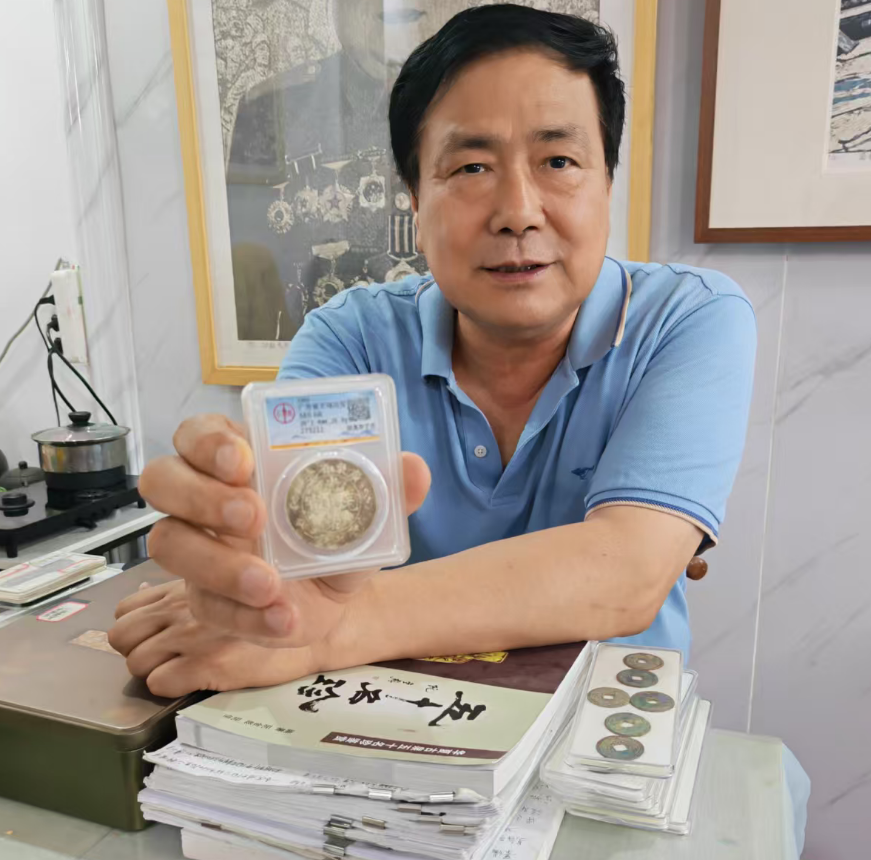 阮金彪展示自己收藏的清代“银元”。