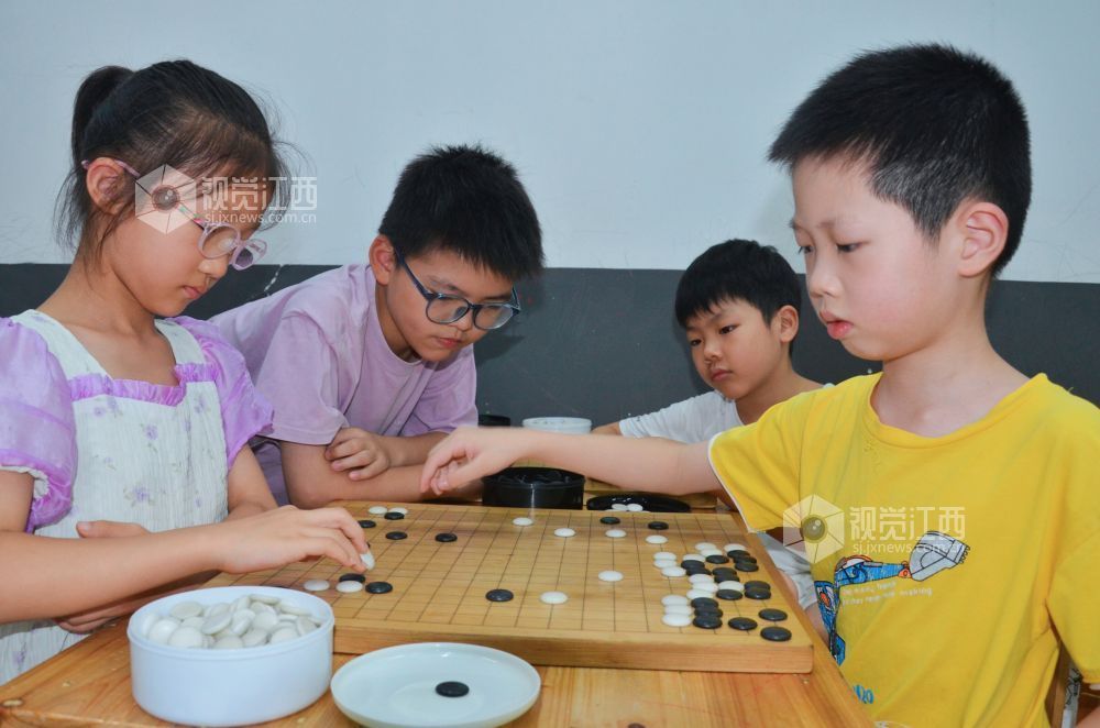 7月29日,江西省永新县欧洲城博卡棋院内,孩子们正在下围棋。