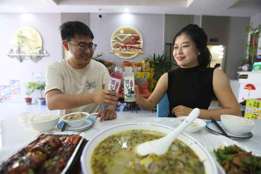 7月28日,在甘肃省天水市武山县的一家餐馆,顾客品尝浆水排骨和浆水饮料。新华社发(王克贤 摄)