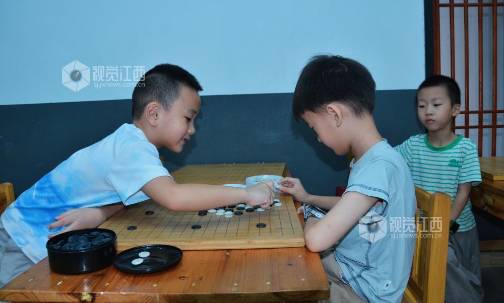 7月29日,江西省永新县欧洲城博卡棋院内,孩子们正在下围棋。