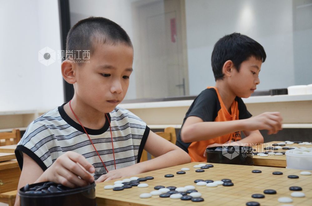 7月29日,江西省永新县欧洲城博卡棋院内,孩子们正在下围棋。