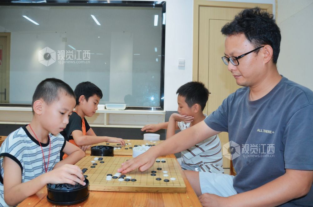 7月29日,江西省永新县欧洲城博卡棋院内,孩子们正在下围棋。