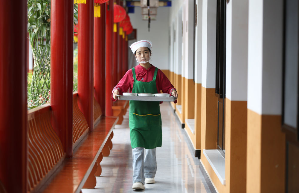 7月27日,甘肃省定西市安定区一家餐馆的服务员为顾客送浆水搅团。新华社发(王克贤 摄)
