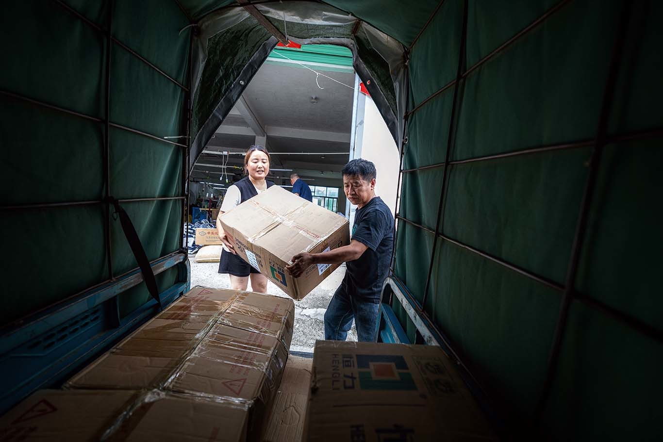 ▲王秀娟（左）和她的丈夫王登云将产品装车，准备发往外地。