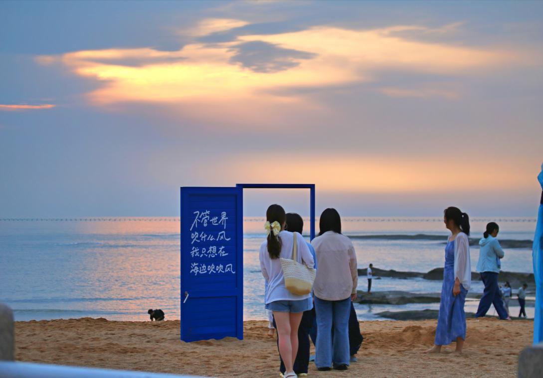 游客有序站在海岸网红打卡点排队,大家争相定格滨海风光。张守本 摄