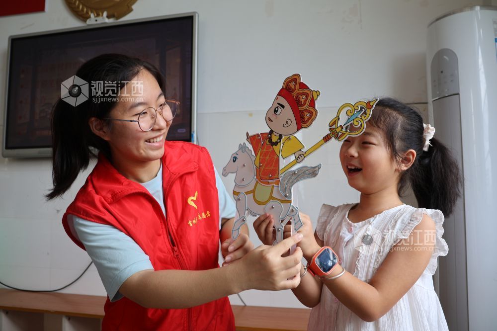 2026年7月28日,在江西省吉安市吉州区兴桥镇兴桥中心小学童心港湾,志愿者正在陪伴孩子们出演皮影小戏。