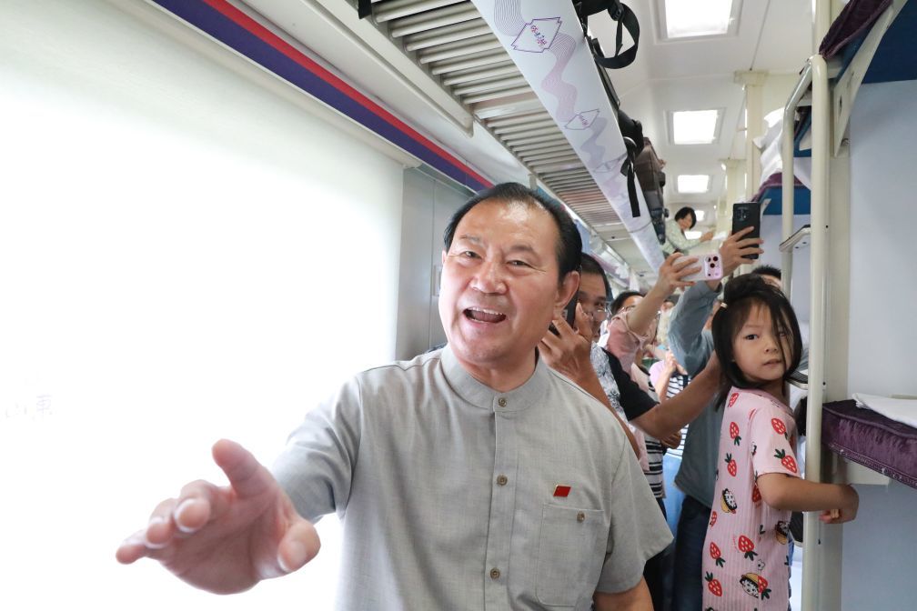 山东省级非遗口技项目代表性传承人苗龙在列车上为旅客表演。(王宇琦 摄)