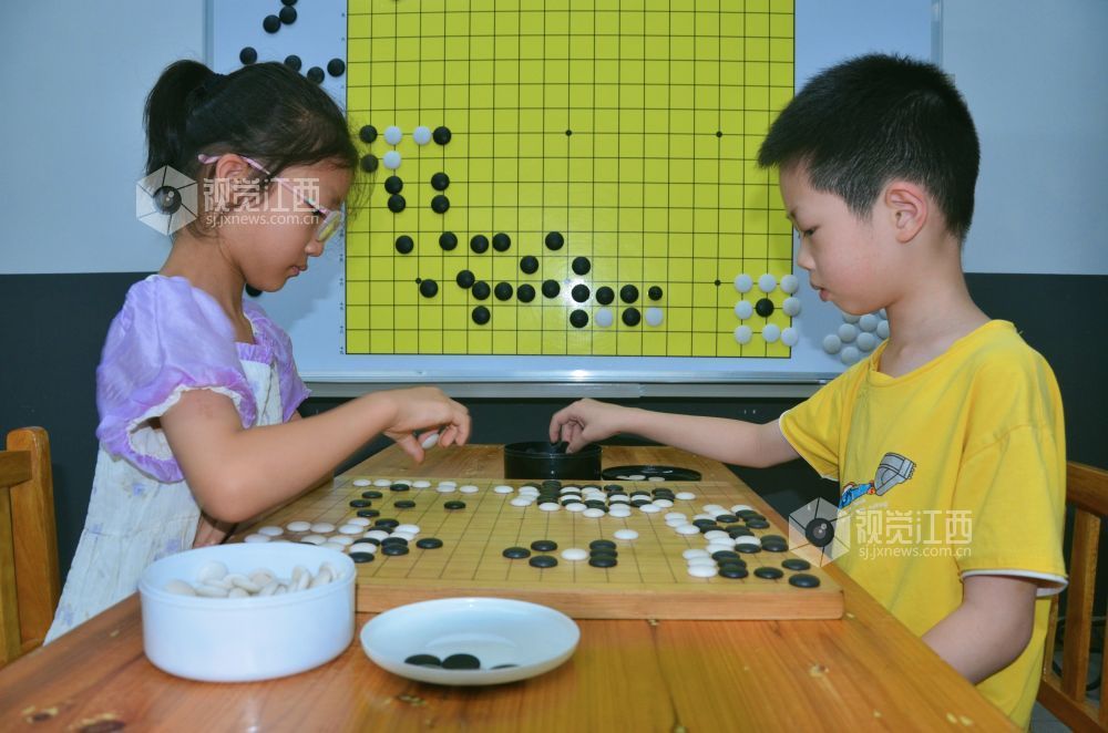 7月29日,江西省永新县欧洲城博卡棋院内,孩子们正在下围棋。