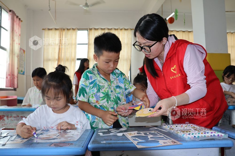 2026年7月28日,在江西省吉安市吉州区兴桥镇兴桥中心小学童心港湾,志愿者正在指导孩子们制作皮影人物。