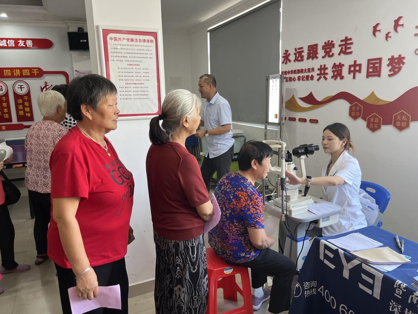 在工作人员指导下，长者们在有序排队检查眼睛