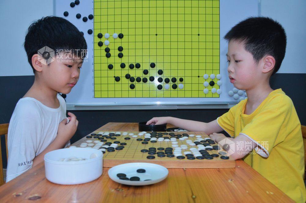 7月29日,江西省永新县欧洲城博卡棋院内,孩子们正在下围棋。