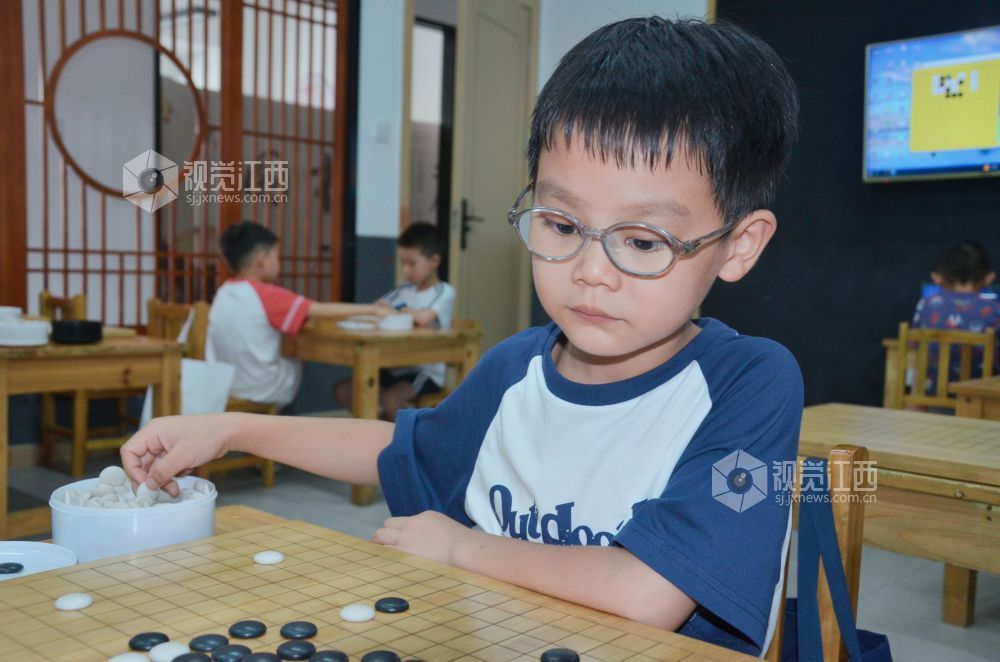 7月29日,江西省永新县欧洲城博卡棋院内,孩子们正在下围棋。