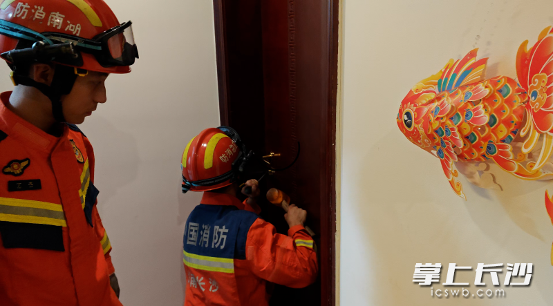 消防员破门营救。 均为长沙晚报通讯员时小尧摄