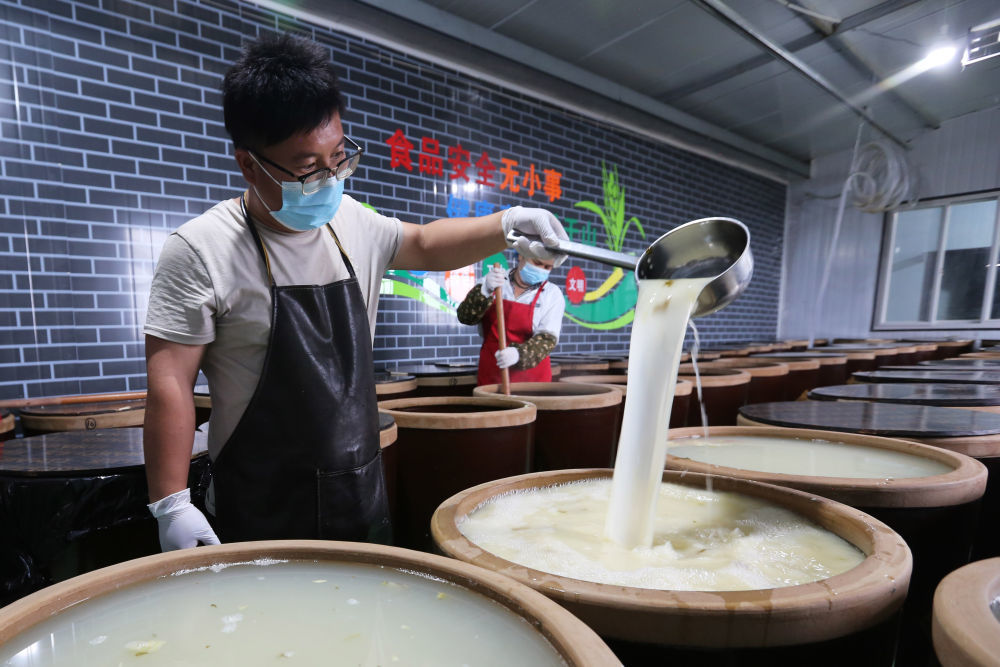 7月10日,甘肃省定西市安定区石峡湾乡一家合作社的工人在浆水制作车间忙碌。新华社发(王克贤 摄)