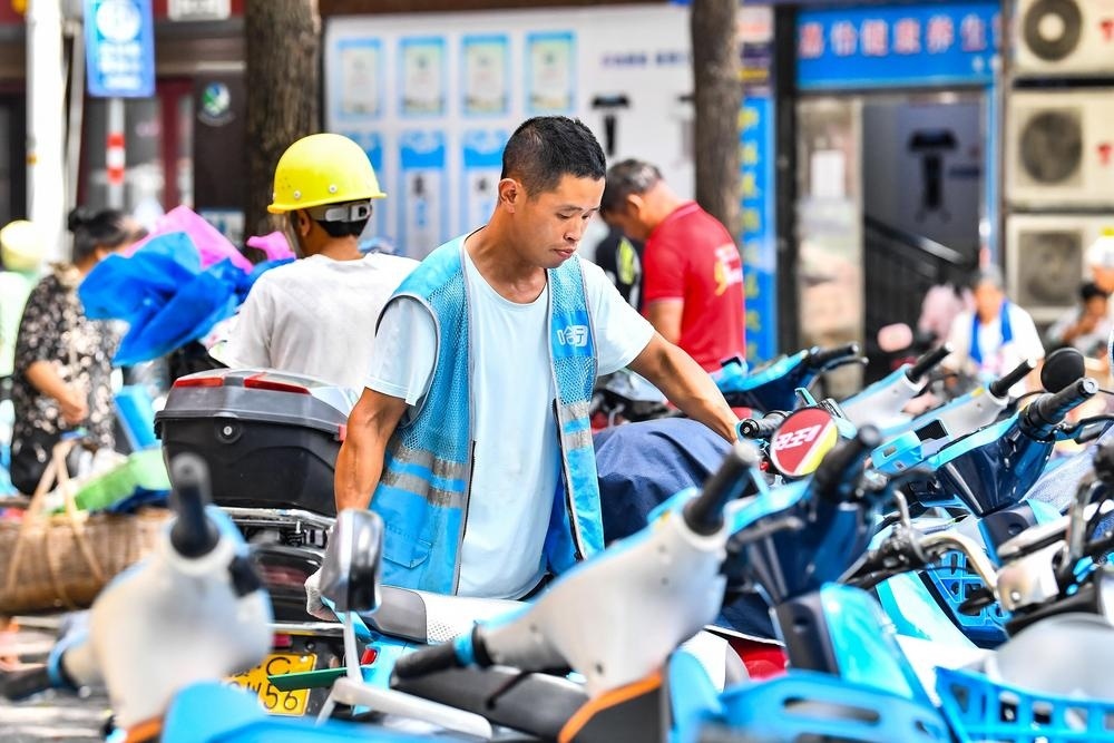 共享单车调度员将单车规整到位。