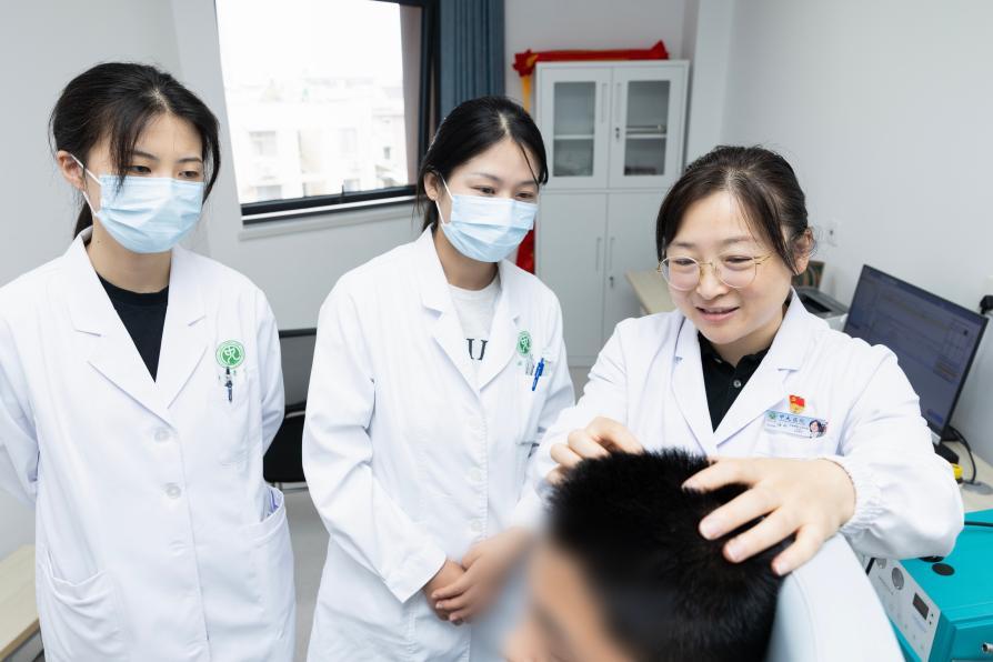 陆玲主任（右一）及团队为阳阳进行人工耳蜗植入术后复诊。张鑫/摄