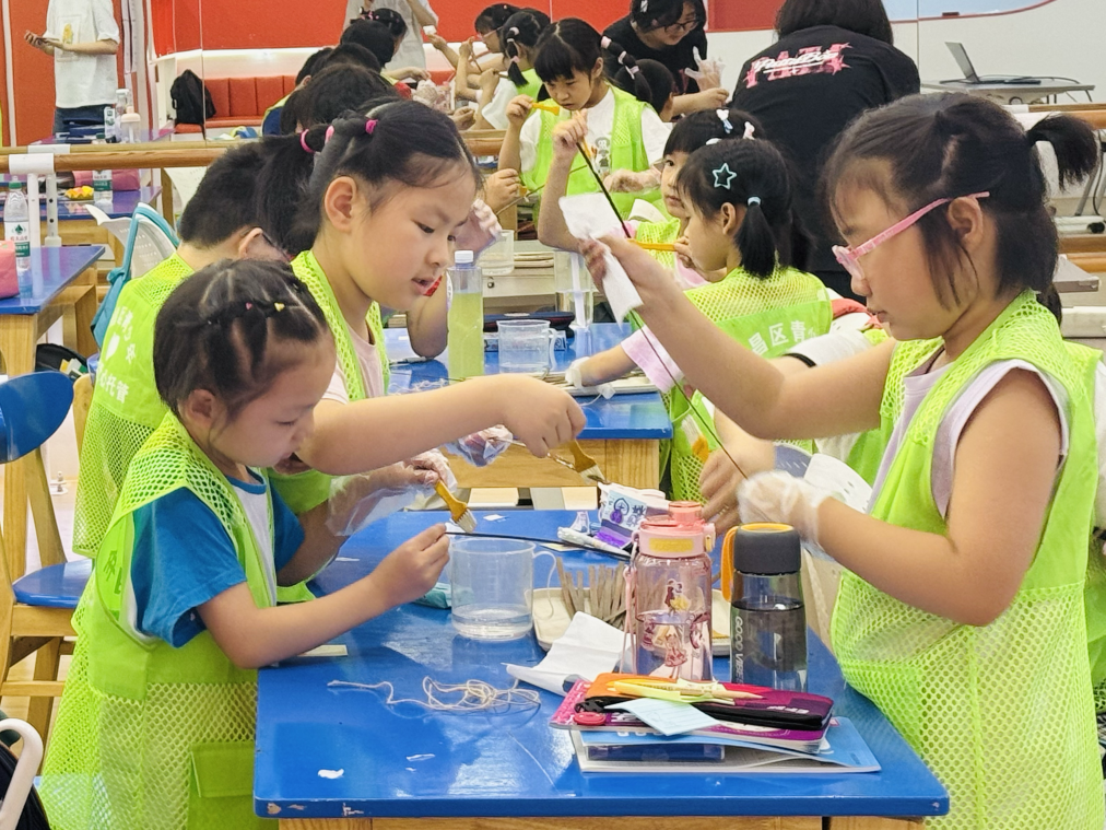7月28日,长城汇楼宇托管班的孩子们在志愿者的指导下修复楚简。新华社记者 余熙 摄
