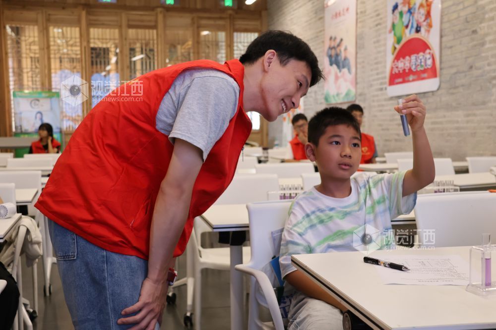 2026年7月29日，在江西省吉安市吉州区庐陵县学托管班，志愿者正在指导孩子们观察实验现象。